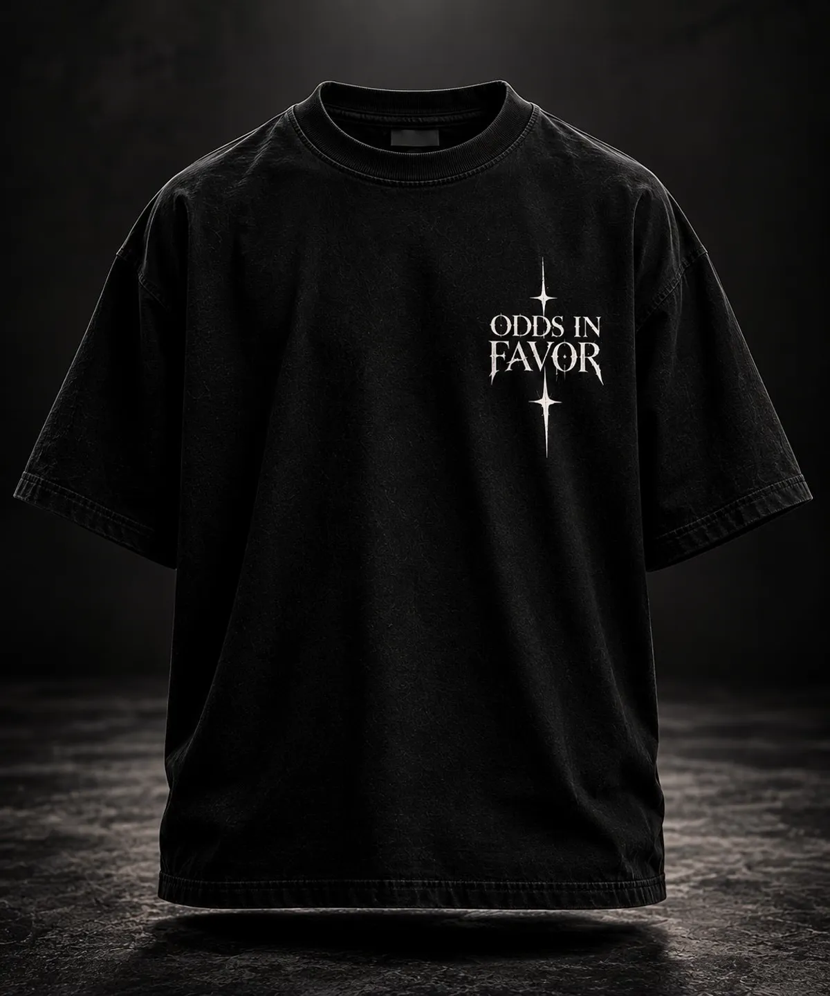 Black oversized T-shirt, front: small ODDS IN FAVOR chest print with star accents